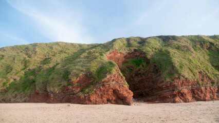 Pared rocosa de arcilla en loma de hierba en playa