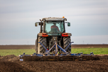Landscape view of a farmer plowing fertile fields under a vast sky