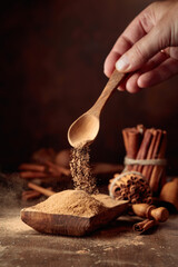 Cinnamon powder is poured into a wooden bowl.