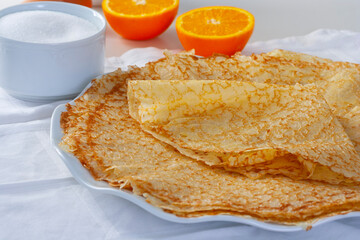 Crepes on white tablecloth, Thin and fresh homemade orange crepes for breakfast or dessert...