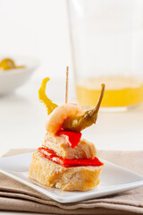 Pintxo or Basque pincho. Delicious Spanish tapa with red pepper tuna, shrimp and chilli...