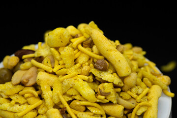 Indian Tea-time snacks like sev, chivda, farsan, mixture, boondi, bakarwadi etc served in white wooden box with cells. selective focus