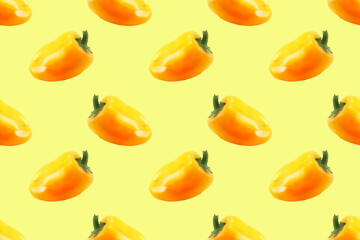 Pattern of ripe yellow bell peppers on a yellow background