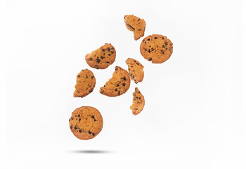 Flying chocolate cookies with slices and crumbs on a white background. Levitation of food