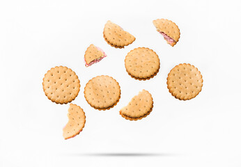 Flying white sandwich cookies with pink strawberry cream on a white isolated background