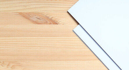 White blank paper on a wooden table, top view. A small stack of A4 sheets on the desktop, close-up....