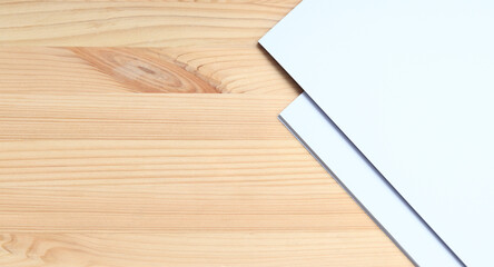 White blank paper on a wooden table, top view. A small stack of A4 sheets on the desktop, close-up. Blank paper, space for text, mockup