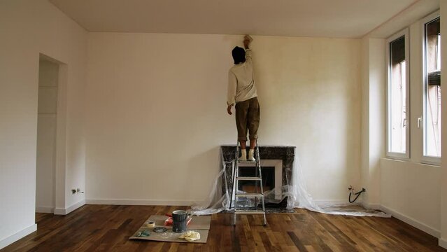 Skilled Man Painter Working Inside A Newly Renovated Space. Limewash Paint Interior. Static Shot
