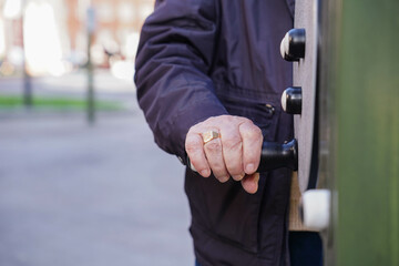 elder hand holding a piece of a outdoor gym in a park