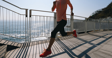 Fitness sports woman runner running on seaside trail