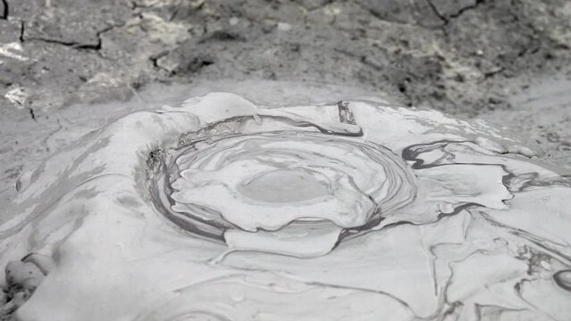 Mud volcano concept: Slow-motion video of clayey mud bubbles leaking out of the ground from mud volcanoes in the badlands
