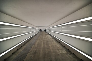 perspective view of a long illuminated underpass almost deserted - obrazy, fototapety, plakaty