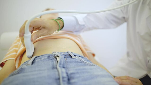 Ultrasound exam on a young woman's abdomen.