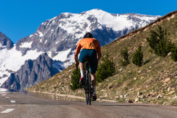 A man is riding a bike down a road with a mountain in the background