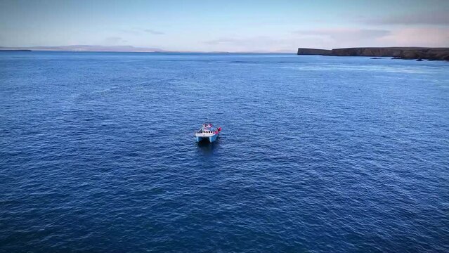 Aerial shot of small creel boat off the coast of Burwick hamlet in the Orkney Islands, Scotland, UK