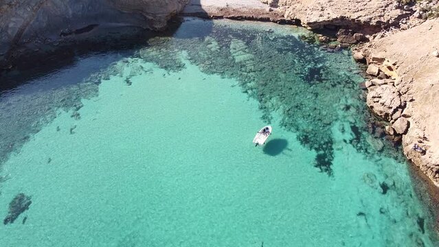 Drone shot of a boat moored off the rocky shoreline of Palma city, Mallorca island, Spain
