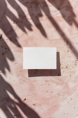 A white square is on a pink wall with a shadow of it