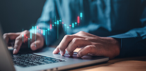 chart, graph, index, candlestick, bar, invest, marketing, profit, report, strategy. A man is typing on a laptop with a graph. The graph is showing a trend, which could indicate a loss in the stock.