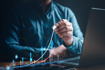 chart, diagram, graph, index, invest, marketing, growth, analytics, opportunity, analysis. A man is drawing a graph on a laptop, with a line is pointing upwards. The graph is showing a positive trend.