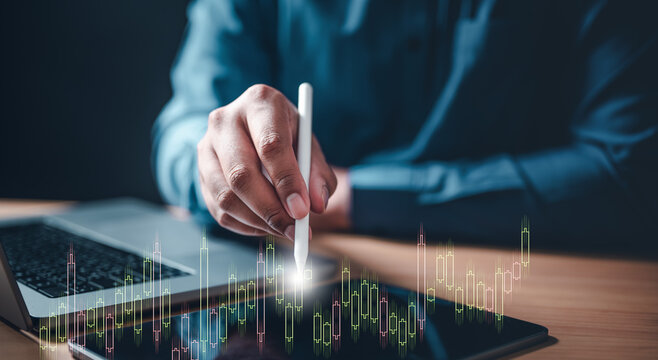 chart, graph, index, intelligent, invest, math, multi, report, diagram, statistic. A man is using a stylus to draw on a tablet. The tablet is displaying a graph. The man is focused on the graph.