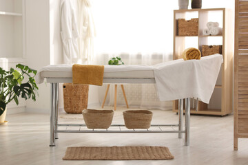 Comfortable massage table with clean towels in spa center
