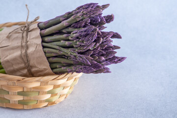 Bunch of asparagus Pacific Purple. Fresh spring vegetable in basket. Copy space background © Real_life
