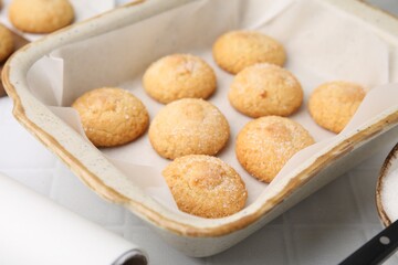 Tasty sweet sugar cookies in baking dish on white tiled table, closeup