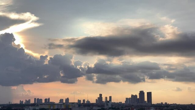 4K City Panoramic Video. Magnificent view of sunset sky with beautiful combination of blue sky colors, ember sun lights, and several unique floating clouds above the city downtown skyline silhouette s
