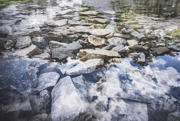 Transparent water of mountain lake Ziyorat and stones at the bottom in the Fan Mountains in Tajikistan