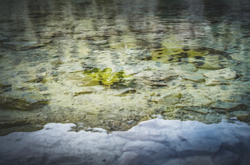 Transparent water of mountain lake Ziyorat and stones at the bottom in the Fan Mountains in Tajikistan