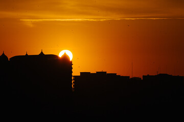 Sunset over the black silhouette of the city