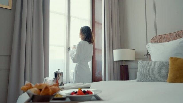 Woman in Bathrobe by Hotel Window