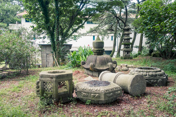Japanese garden with a granite lantern and other objects of religious worship made of granite