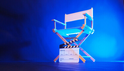 Director chair and clapper board in blue light.