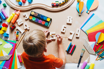 Child drawing and making crafts in school or daycare. - 791548647