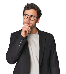 Young Hispanic businessman looking sideways with doubtful and skeptical expression.