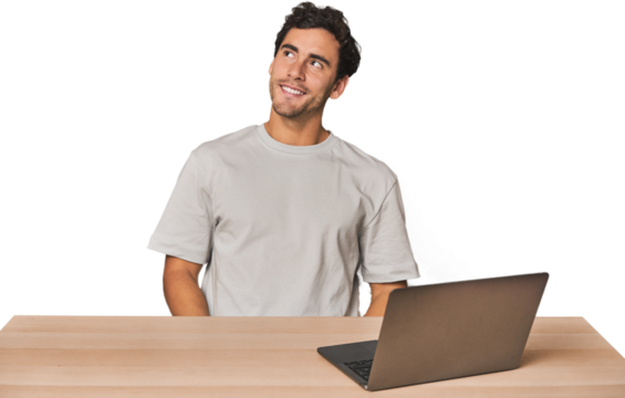 Hispanic young man working on laptop relaxed and happy laughing, neck stretched showing teeth.