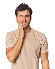 Young Hispanic man in studio having a strong teeth pain, molar ache.