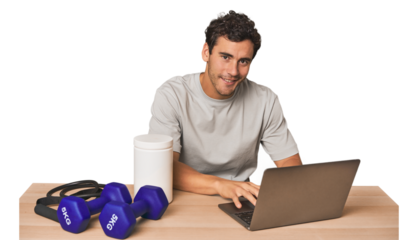 Hispanic male trainer with laptop planning workouts
