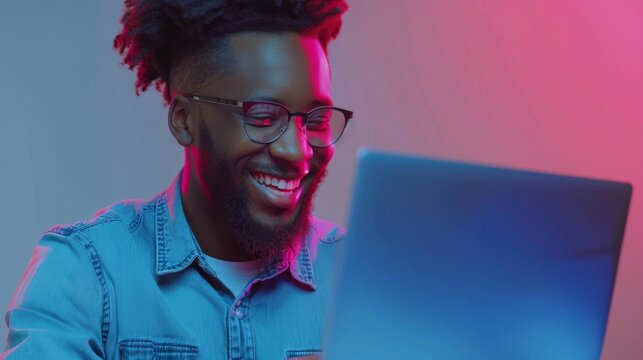 Man Smiling at Colorful Laptop Screen