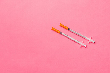 Top view of two insulin syringe at colorful background with copy space. High level of glucose...
