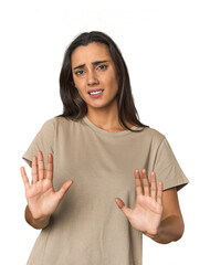 Hispanic young woman rejecting someone showing a gesture of disgust.
