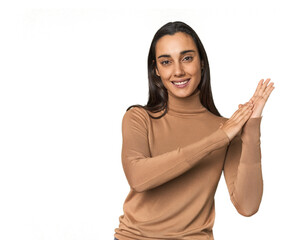 Hispanic young woman feeling energetic and comfortable, rubbing hands confident.