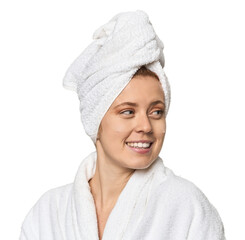 Young Caucasian redhead after shower looks aside smiling, cheerful and pleasant.