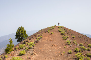 A young woman walking towards Birigoyo peak, La Palma Island, Canary Islands. - obrazy, fototapety, plakaty
