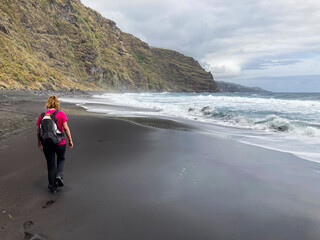 A young woman walking towards the Nogales beach, La Palma Island, Canary Islands.