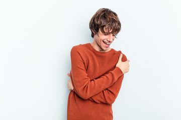 Young caucasian man isolated on blue background laughing and having fun.