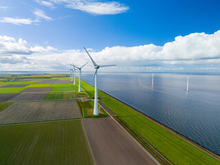 A mesmerizing aerial view of a wind farm with rows of majestic windmill turbines spinning gracefully near the vast ocean, harnessing energy from the gusts of wind