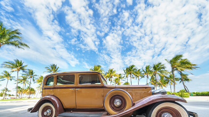 Yellow classic car on a tropical beach with palm tree.