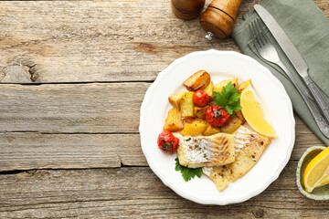 Tasty cod cooked with vegetables served on wooden table, flat lay. Space for text